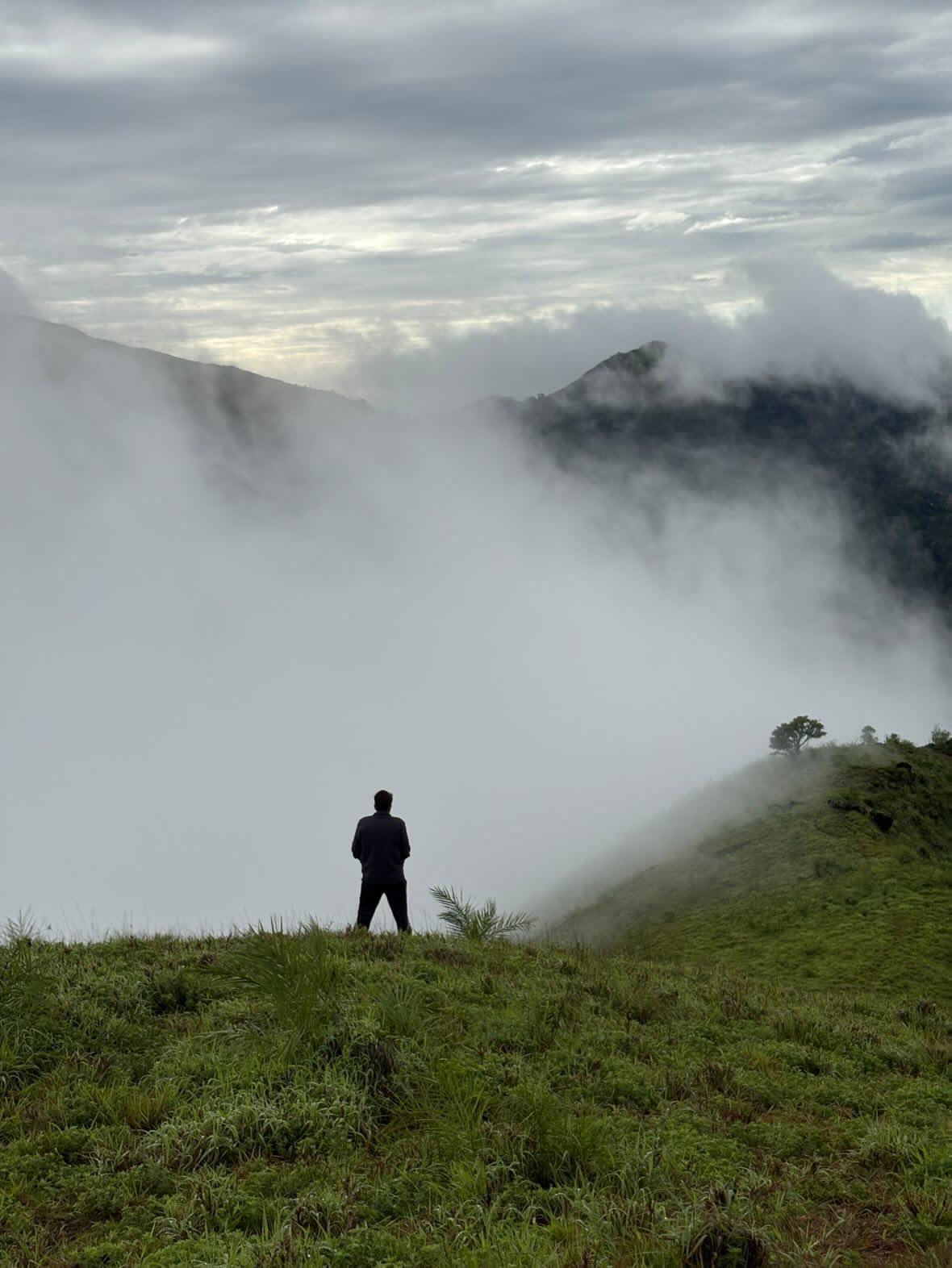 A foggy mountain peak rising above a sea of clouds at dawn